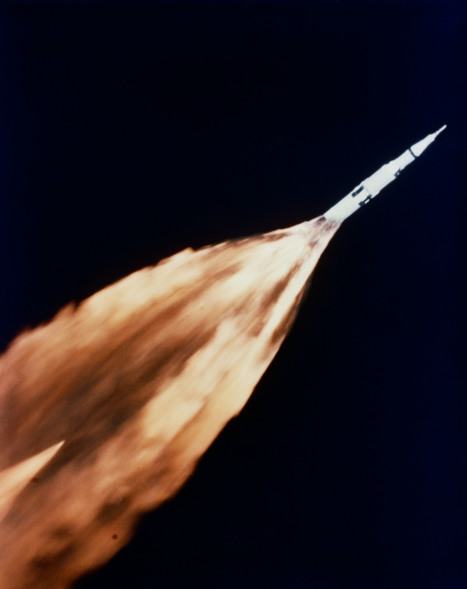 A Saturn rocket lifting off with a trail of flames