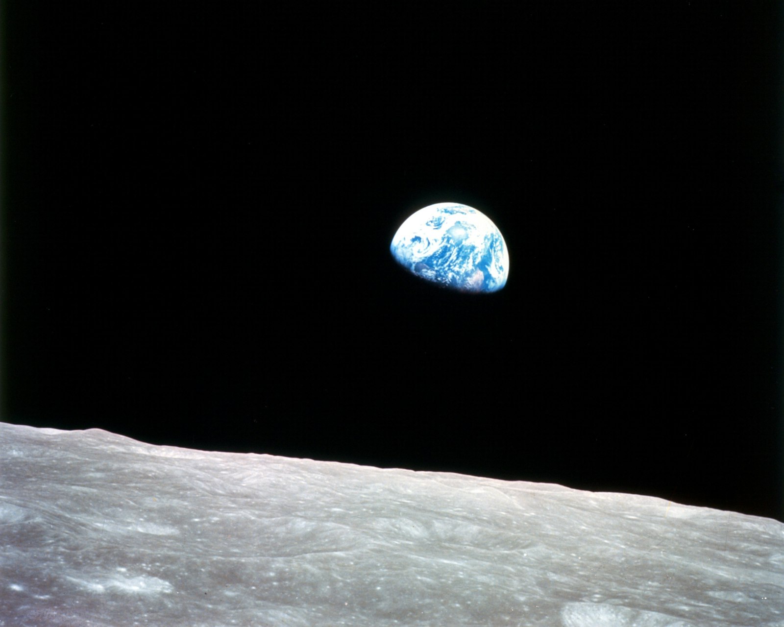 Earth rising above the lunar surface, seen from space